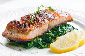 Grilled salmon served with leafy greens
